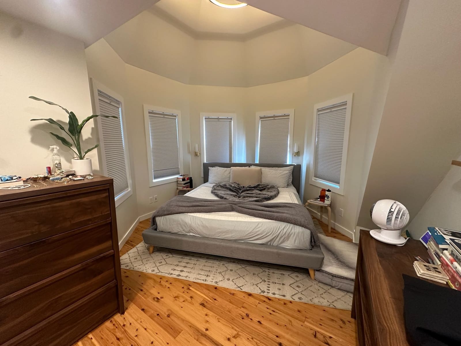 Bedroom with a made bed and folded throw in front of a bay window