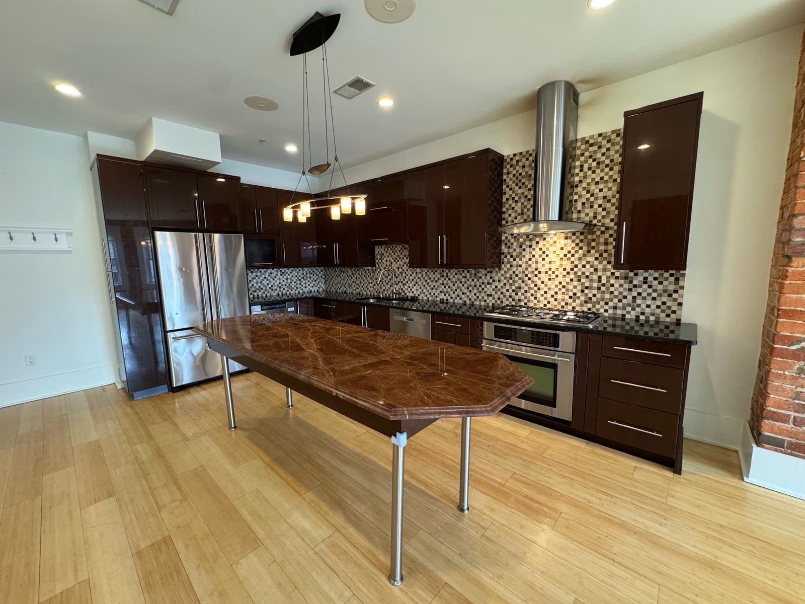 Kitchen with dark glossy cabinets and a long wood-top island