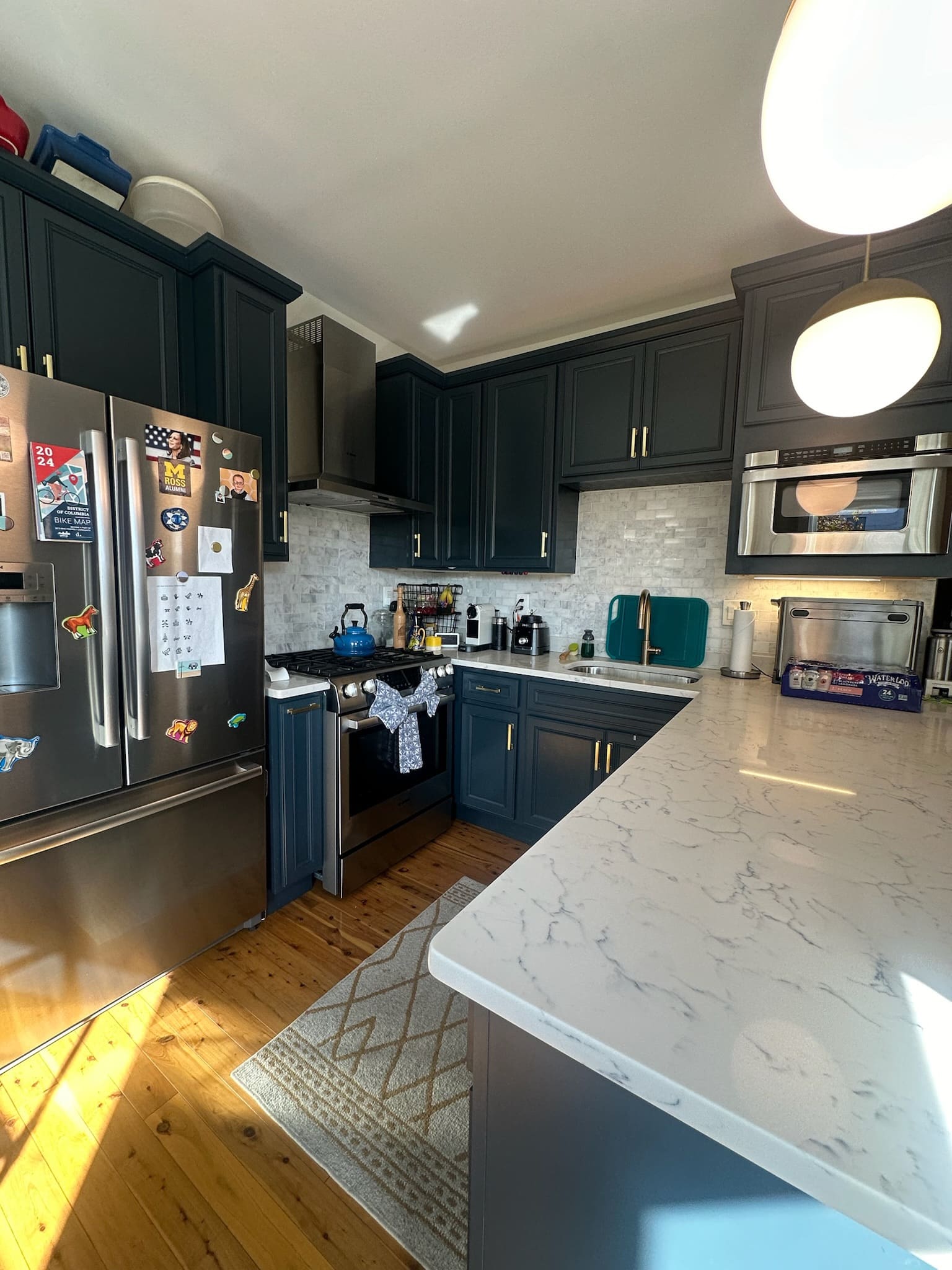 Kitchen with navy cabinets, white marble counters and stainless appliances